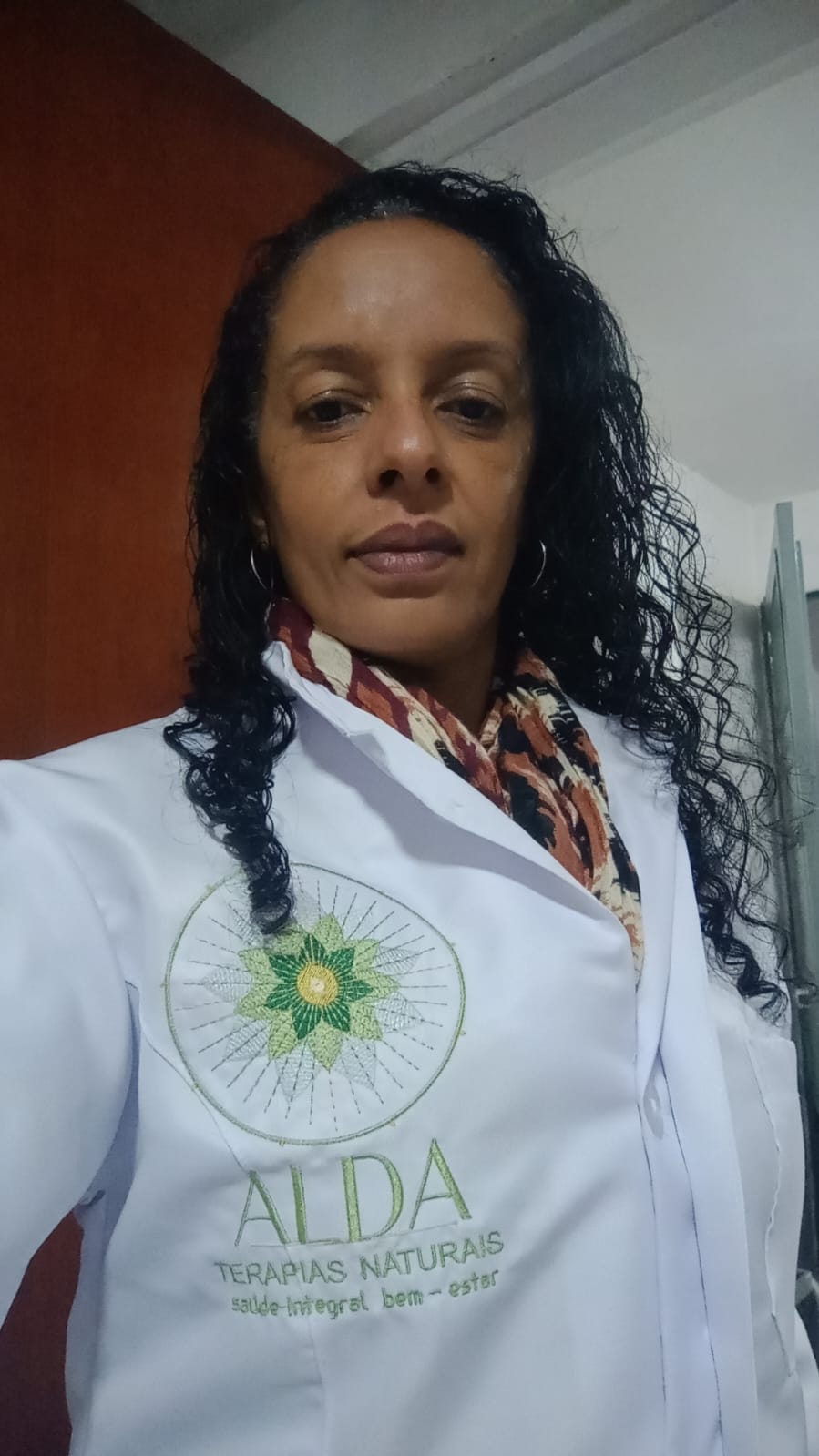 Alda Marinez com jaleco bordado da Alda Terapias Naturais
